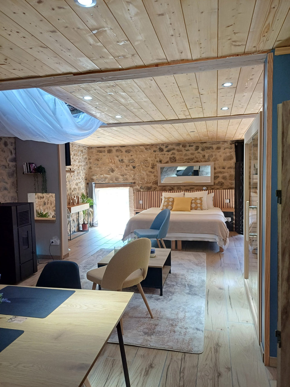 Suite romantique Mas du Martinet : chambre luxe avec lit baldaquin, baignoire îlot et fauteuils rouges, idéale pour séjour amoureux.6 de Mas du Martinet - Suite Romantique