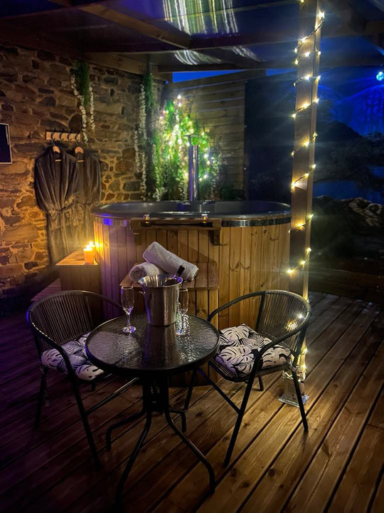 Bouquet de roses rouges et blanches, avec bougie et pétales, sur table en bois romantique.