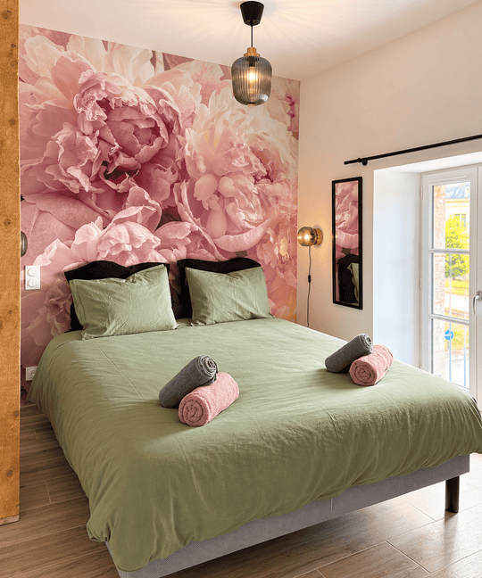 Chambre double avec grand lit et décor floral